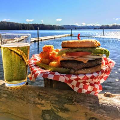 Hamburger in a basket with a beer overlookcing Siltcoos Lake